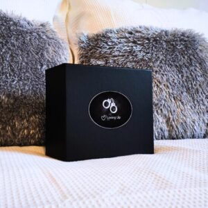 Coffret élégant noir avec au milieu une étiquette en cercle, avec l'image d'une paire de menotte