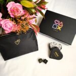La Love Box est présentée avec ses produits phares, accompagnés d'un beau bouquet de fleurs et de sa trousse à jouets.