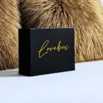 Coffret élégant noir avec au milieu gravait de couleur or le nom de la love box "lovebox"
