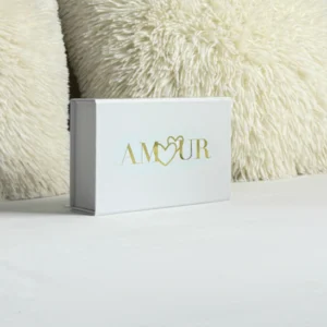 Un coffret blanc élégant, orné au centre du mot "Amour" gravé en or, et intégrant le logo de la marque Loving Up.